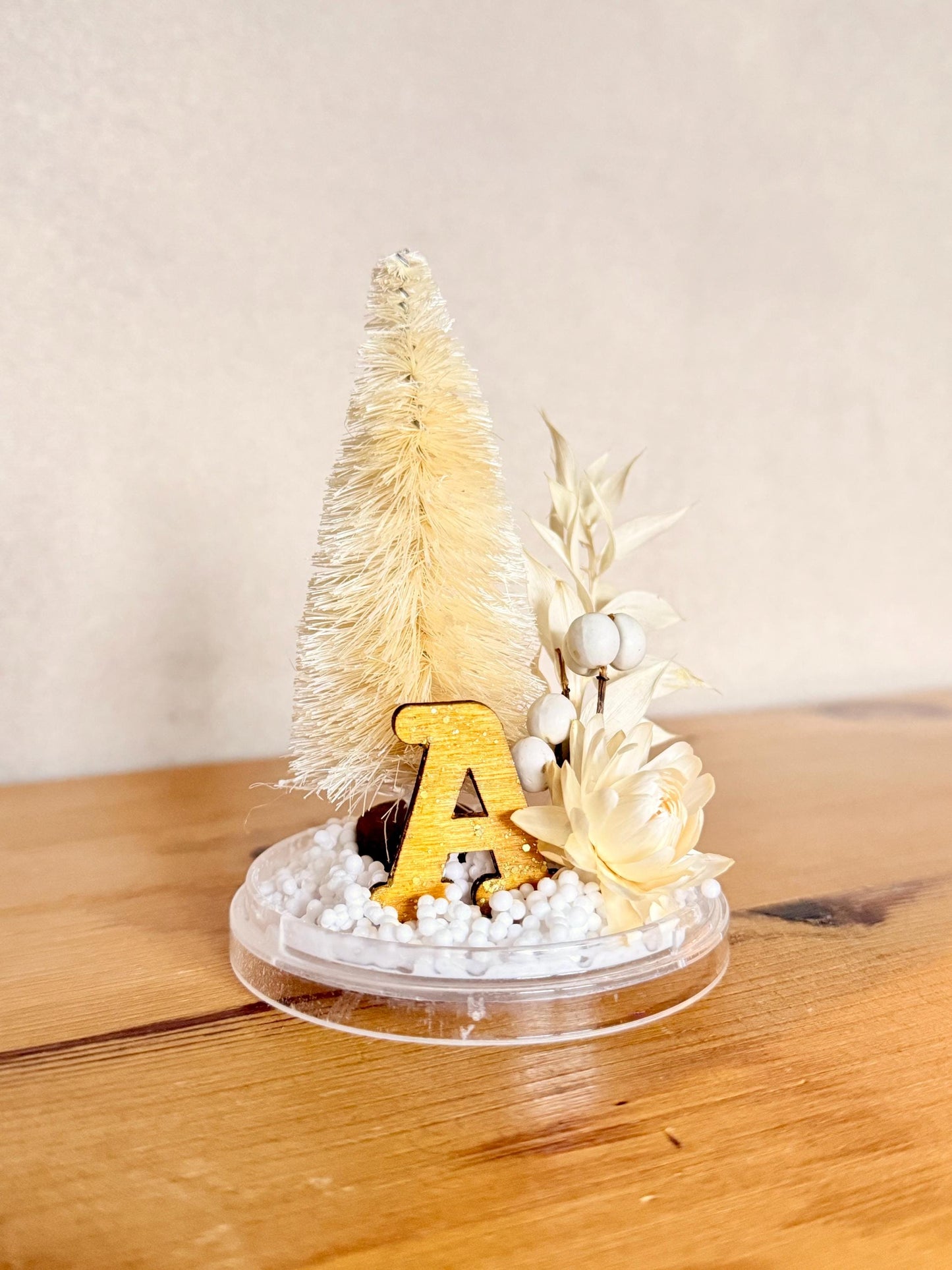 Personalized with initial Ornament - Preserved eucalyptus, dried tallow berries and strawflower, bottlebrush tree and a ochre and sparkle wooden letter on a snow base; hung by a gold color velvet ribbon.