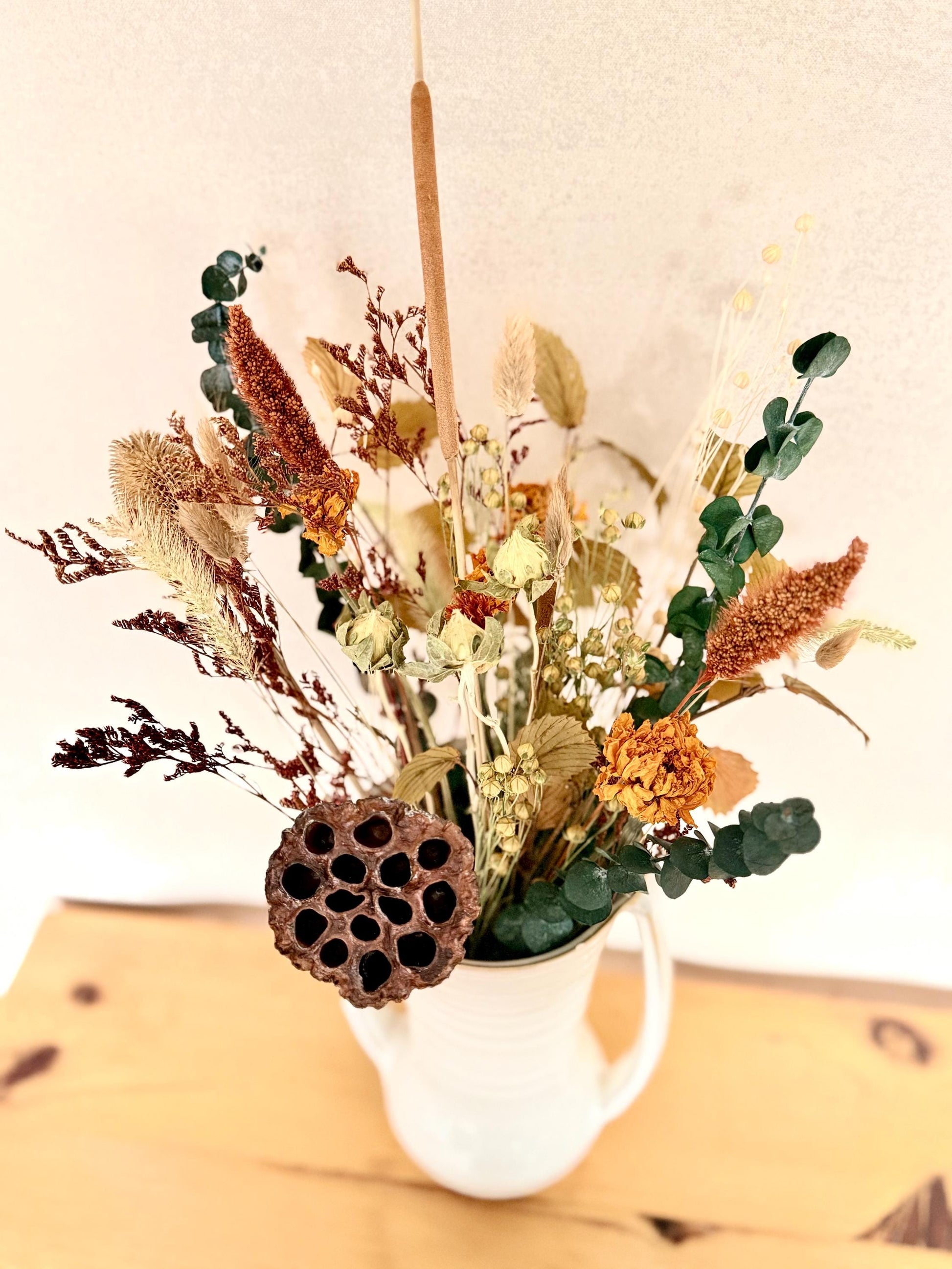 The Blissful bouquet is a stunning Fall inspired bouquet featuring preserved eucalyptus and magnolia, dried marigolds, millet, flax, pods and bunny tails. Stunning as a centerpiece for your Thanksgiving table or all year round for the Fall lovers.
