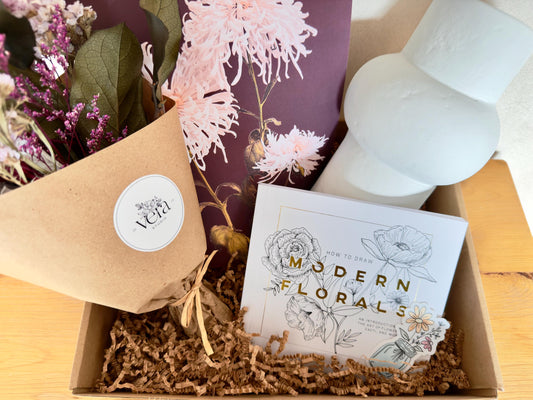Gift box that includes a dried bouquet by Vera Studio, paper mache vase, modern flowers drawing book, print by Ogawa Kazumasa and flower bouquet sticker by Artist Megan Morole.