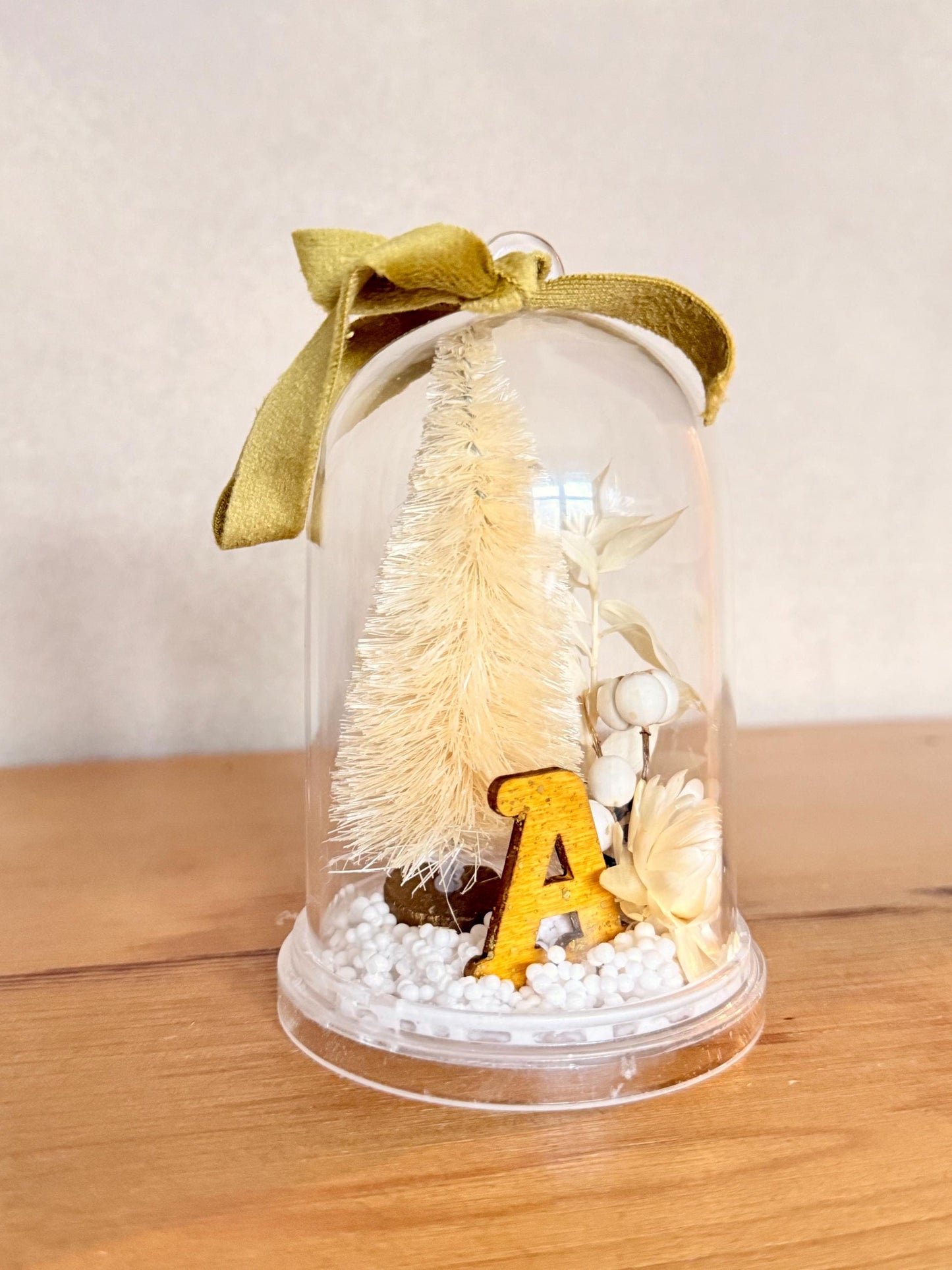 Personalized with initial Ornament - Preserved eucalyptus, dried tallow berries and strawflower, bottlebrush tree and a ochre and sparkle wooden letter on a snow base; hung by a gold color velvet ribbon.